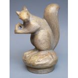 A car mascot formed as a squirrel holding a nut,