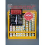 NGK spark plug wall-mounted retail dispenser with approximately 80 unused spark plugs