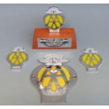 A Guernsey AA car badge and three 40 year anniversary small badges, one Jersey on base,