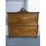 A French walnut bed with carved decoration comprising headboard,
