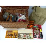 A collection of fishing equipment including a wicker basket,