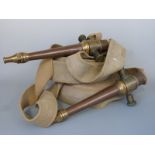 Two vintage canvas fire hoses with bronze/copper nozzles and fittings