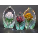 Three Mats Jonasson coloured floral paperweights,