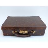An Edwardian brown leather case with silk lining, embossed with gilt fleur de lys,