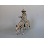 A Tang style cast metal model of a man on a donkey
