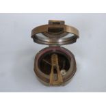 A brass military compass marked Brinton Compass,