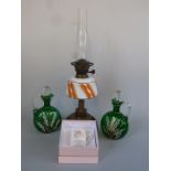 An oil lamp and two enamelled glass decanter jugs