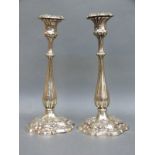 A pair of plated candlesticks with relief decoration of foliage, 28.