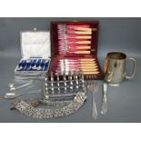 A plated pierced nurse's belt, heavy toast rack, cased spoons,