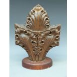 A carved oak fleur-de-lys finial on plinth,