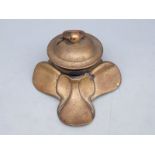 A brass inkwell in the form of a saddle, 9cm tall,