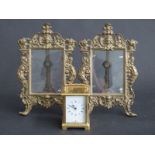 A pair of brass photograph frames and a brass cased carriage clock