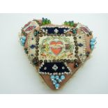 A heart-shaped possibly WWI era sweetheart pin cushion with a collection of glass-topped pins