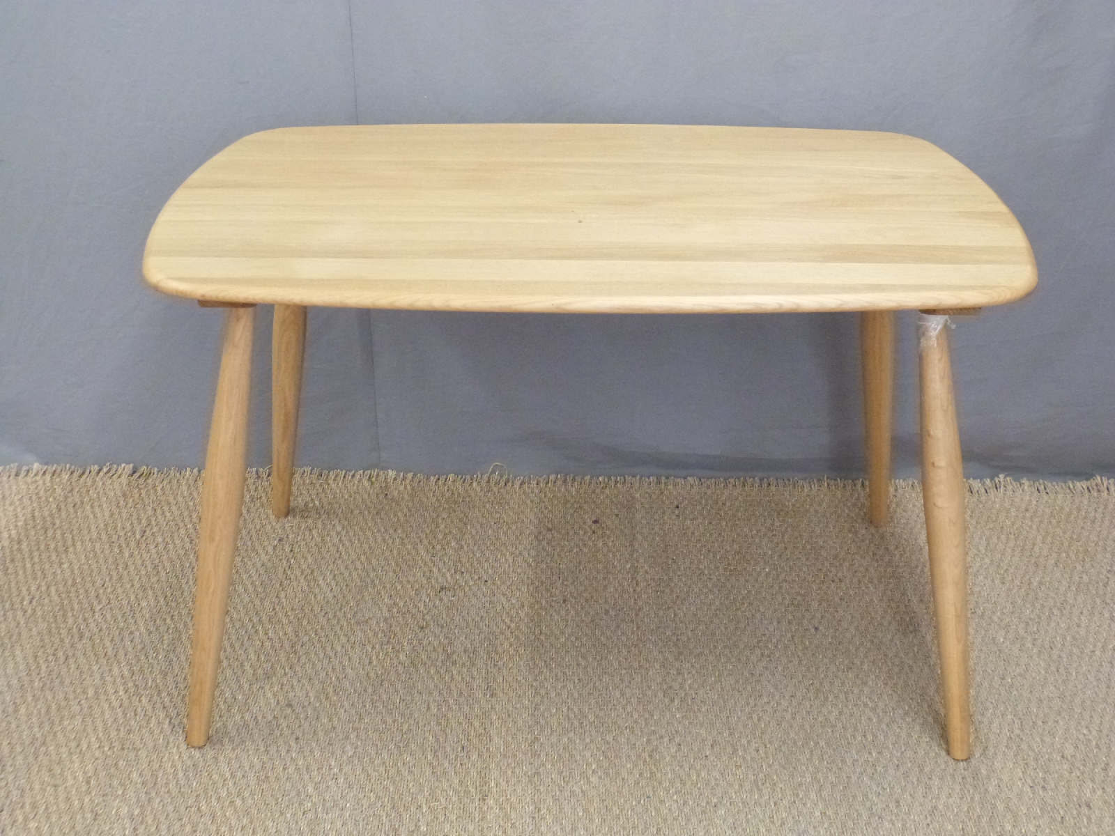 Ercol light elm curved rectangular table, new and unused,