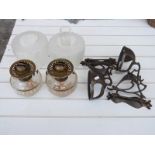 A pair of Arts & Crafts / Art Nouveau hammered copper oil lamps with glass shades
