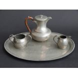 A pewter coffee pot, milk jug and sugar bowl on a tray,