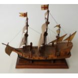 A hand built wooden model of an Elizabethan galleon on wooden plinth,