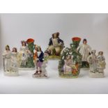 Seven Staffordshire figures including a pair of spill vases,