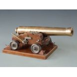 Signalling or display model cannon with 33cm graduated brass barrel raised on oak carriage and