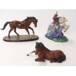 Three Royal Doulton racehorses including The Winner, and a boxed Beswick horse lying down,