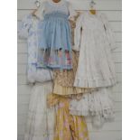 Seven dolls / children's dresses or part outfits some with lace decoration and printed patterns