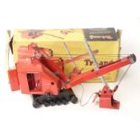 Tri-ang pressed steel excavator with red body, black base and black tracks, in original box.