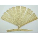 A 19thC Chinese carved ivory fan depicting court scenes and a fish shaped letter opener