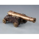 Signalling or display model cannon with 29cm graduated brass barrel raised on oak carriage,