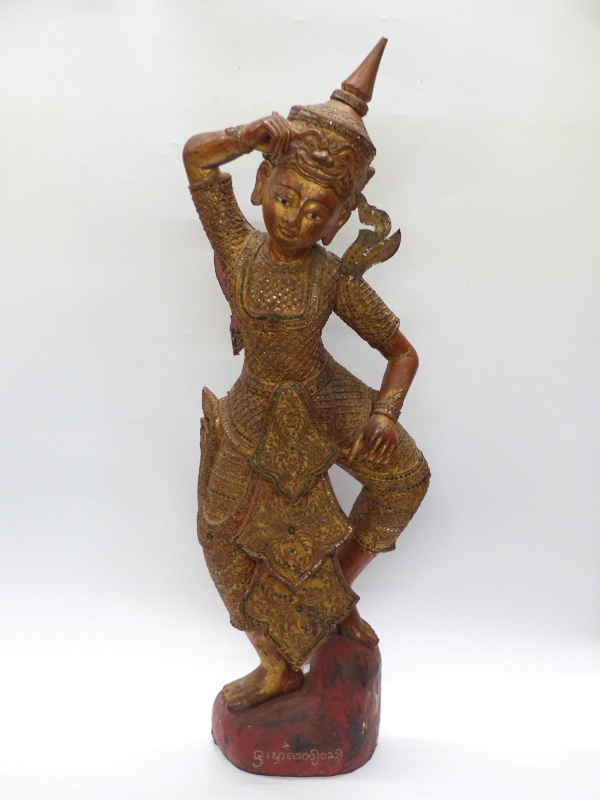 A carved and gilded Cambodian Kinnaris Temple Dancer with script to base,