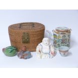 A famille rose tea pot and cup in wicker carrier,