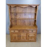 Pine dresser with plate rack top, the base fitted three drawers and three cupboards,