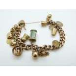 A 9ct gold charm bracelet with 17 9ct gold charms including 1 dollar coin, thistle, boat, heart,