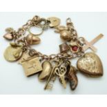 A 9ct gold charm bracelet with fifteen 9ct gold charms including cross pendant, bible, rings,