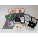 A collection of Danbury Mint and silver commemorative coin packs, includes some silver content,