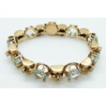 An 18ct gold bracelet set with nine large and nine small round mixed cut aquamarines,