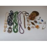 A collection of costume jewellery including agate beads, Art Deco necklaces, compacts, brooches,