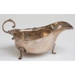 Edward VII hallmarked silver sauce boat raised on three feet, Chester 1909 maker Barker Brothers,