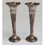 A pair of Edward VII hallmarked silver trumpet vases with embossed decoration,