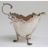Victorian hallmarked silver footed cream jug with scroll handle,