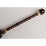 A 19thC parasol with spherical tiger's eye handle and two yellow metal mounts/collars, 89cm,