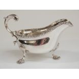 Edward VII hallmarked silver sauce boat with gadrooned edge and raised on shell-shaped feet,
