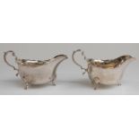 A pair of George V hallmarked silver sauce boats raised on three feet,