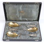 Cased set of three German white metal serving spoons with gilt metal bowls,