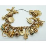 A 9ct gold charm bracelet with 20 yellow metal/ 9ct gold charms,