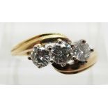 An 18ct gold ring set with three round cut diamonds, the centre diamond approximately 0.