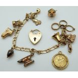 A 9ct gold charm bracelet with various 9ct gold/ yellow metal charms including a heart padlock,