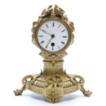 French 19thC gilt metal ormolu style mantel clock in balloon type case surmounted by a pair of