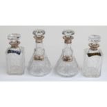 Two pairs of hallmarked silver mounted cut glass decanters with plated or enamel spirit tickets