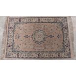 Perisan style rug or prayer mat with blue decoration and fringed ends on pale pink ground,