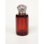 A 19th/early 20thC white metal lidded ruby glass scent bottle with faceted body, height 6.5cm